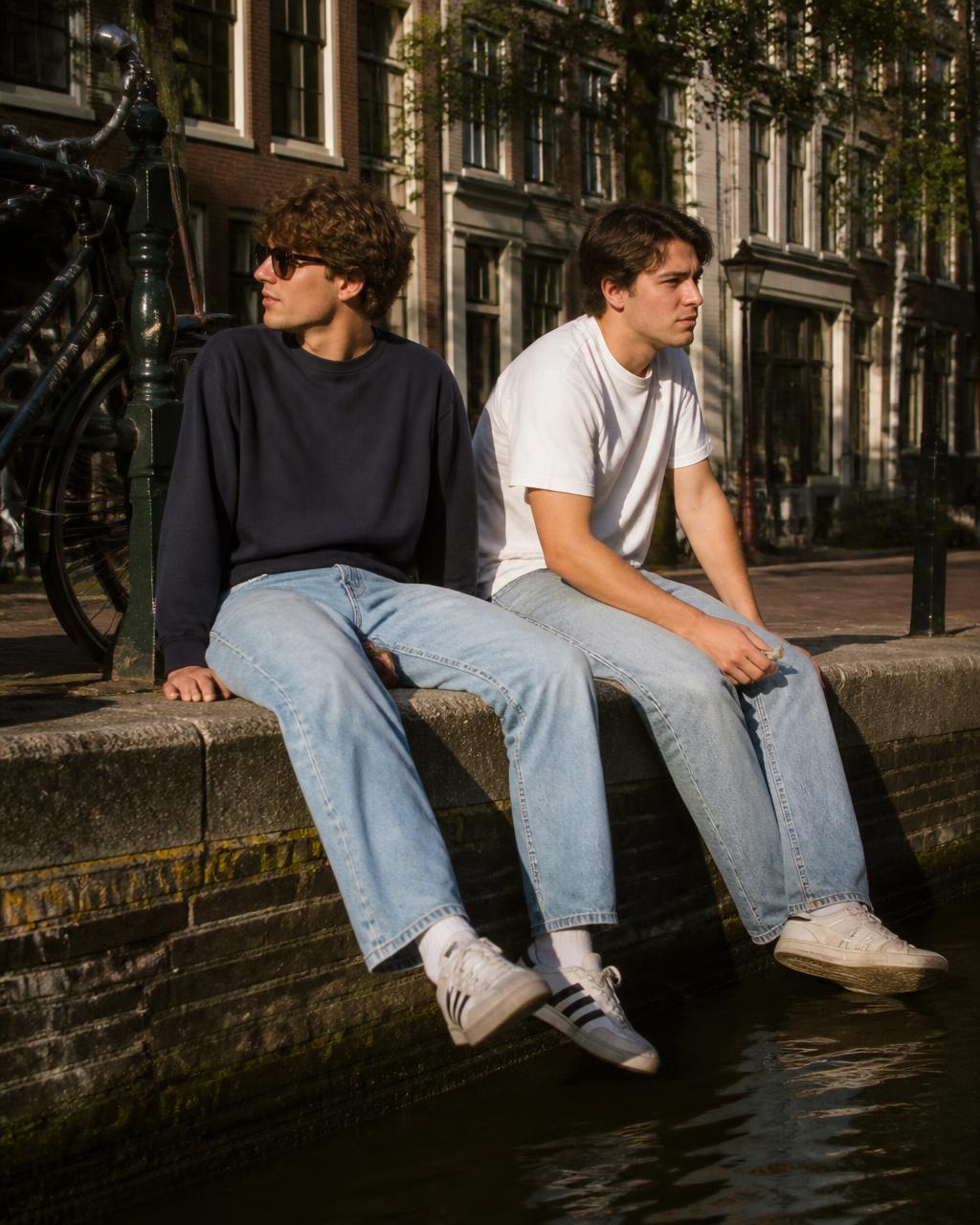 Twee jongens aan de gracht met hun benen boven het water