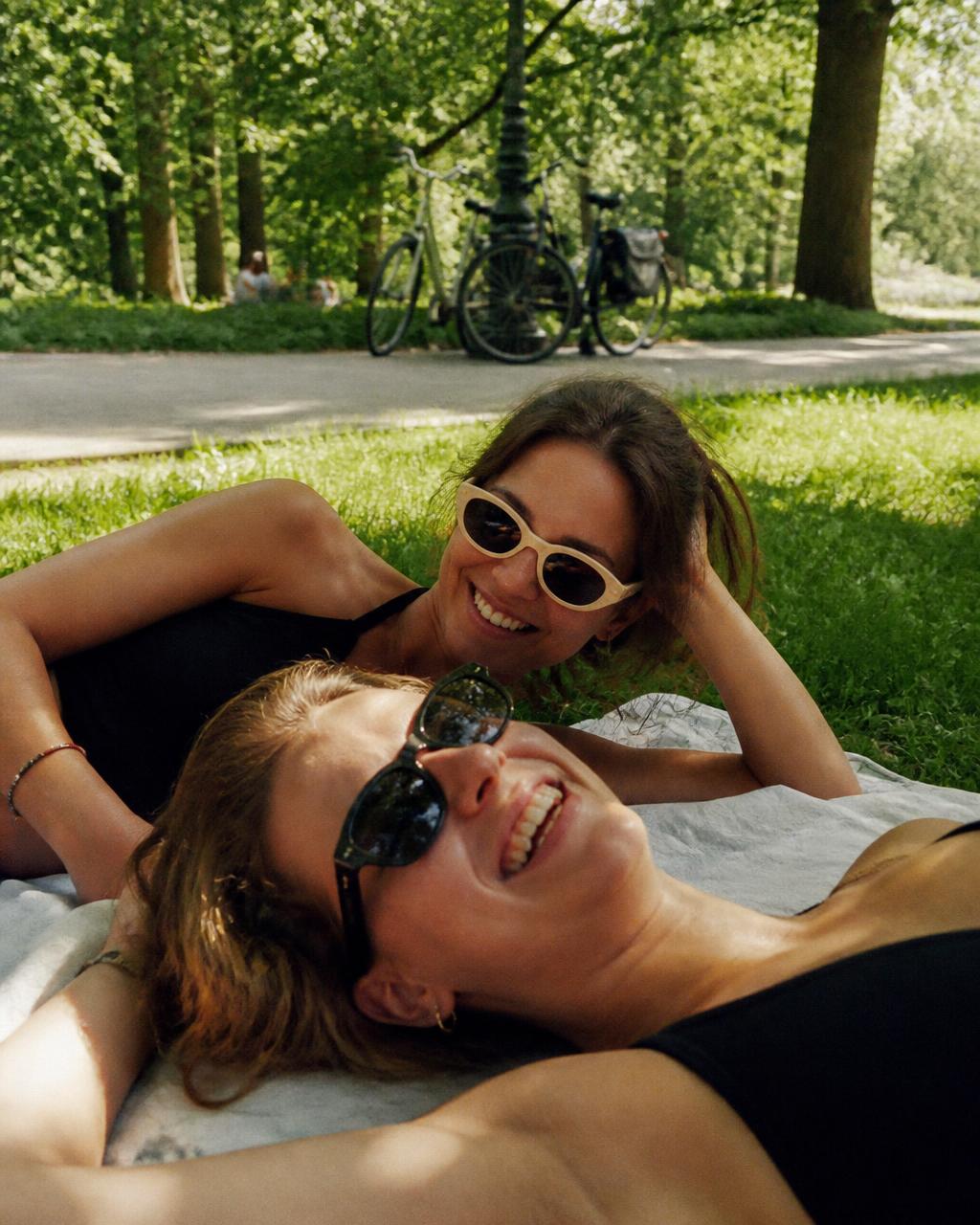 Vriendinnen liggend in het gras in het Vondelpark